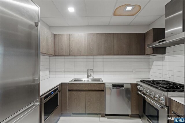 320 Adolphus Ave Unit 317, Cliffside Park, NJ 07010 - kitchen featuring stainless steel appliances, a sink, wall chimney exhaust hood, tasteful backsplash, and light countertops