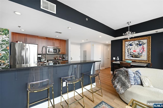 800 Jackson St Unit 505, Hoboken, NJ 07030 - kitchen featuring stainless steel appliances, dark countertops, light wood-style floors, recessed lighting, and a breakfast bar area