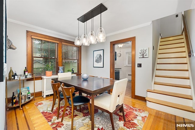 206 Eastern Way, Rutherford, NJ 07070 - dining space with stairway, radiator heating unit, light wood-style flooring, crown molding, and a chandelier