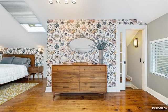 206 Eastern Way, Rutherford, NJ 07070 - bedroom featuring wallpapered walls, lofted ceiling, wood finished floors, and an accent wall