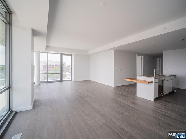 320 Adolphus Ave Unit 401, Cliffside Park, NJ 07010 - unfurnished living room with dark wood-style floors, a sink, and baseboards