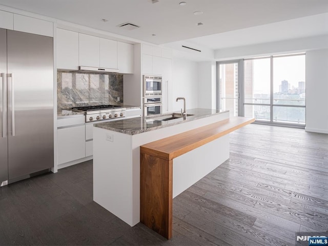 320 Adolphus Ave Unit 401, Cliffside Park, NJ 07010 - kitchen featuring built in appliances, dark wood-style flooring, white cabinets, and a sink