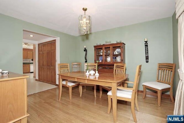 64 Lunn Ave, Bergenfield, NJ 07621 - dining area with light wood-style flooring and a chandelier