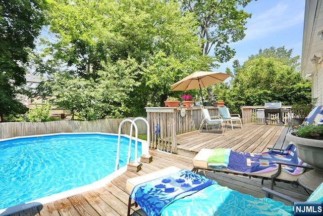 64 Lunn Ave, Bergenfield, NJ 07621 - view of pool featuring a deck, a grill, and view of wooded area