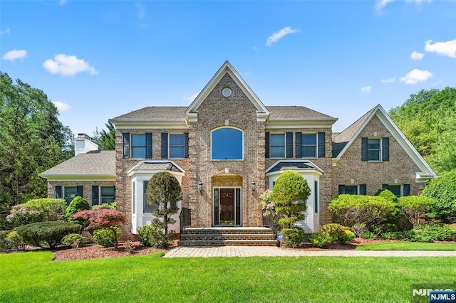 4 Michelle Ct, Harrington Park, NJ 07640 - colonial home with a front lawn, brick siding, and a chimney