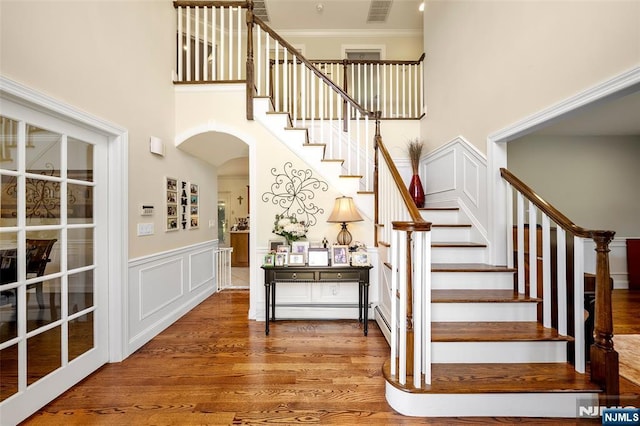 4 Michelle Ct, Harrington Park, NJ 07640 - stairway with arched walkways, a decorative wall, wood finished floors, ornamental molding, and a towering ceiling