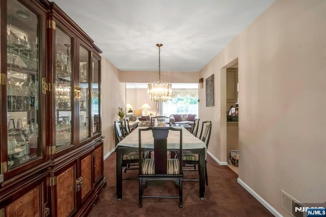 42 Lohs Pl, Harrington Park, NJ 07640 - dining area with dark carpet, a chandelier, and baseboards