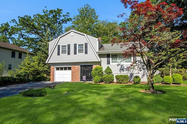 42 Lohs Pl, Harrington Park, NJ 07640 - view of front of house with a gambrel roof, driveway, brick siding, and a front yard