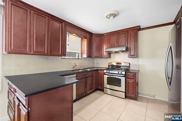 6 Gail Pl, Secaucus, NJ 07094 - kitchen featuring appliances with stainless steel finishes, under cabinet range hood, dark countertops, reddish brown cabinets, and tasteful backsplash