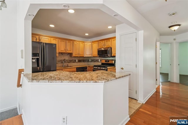 315 Winthrop Dr Unit 3082, Nutley, NJ 07110 - kitchen featuring appliances with stainless steel finishes, a sink, light stone counters, a peninsula, and light wood-style flooring