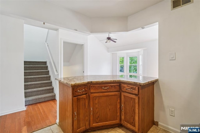 315 Winthrop Dr Unit 3082, Nutley, NJ 07110 - kitchen with light stone counters, a ceiling fan, brown cabinets, baseboards, and lofted ceiling