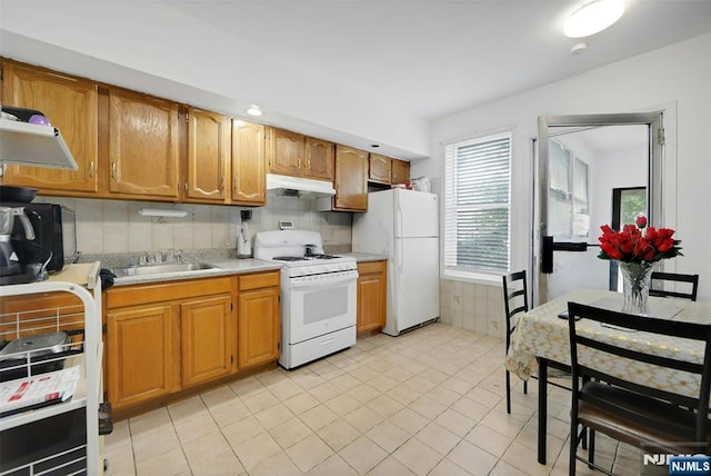 215 48th St Unit 101, Union City, NJ 07087 - kitchen with white appliances, a sink, under cabinet range hood, light countertops, and light tile patterned floors