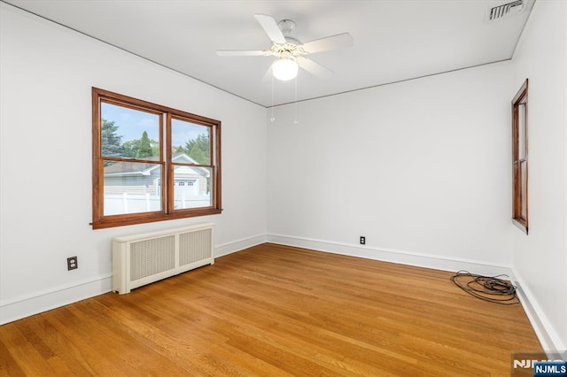 211 Harrison Ave, Hasbrouck Heights, NJ 07604 - spare room featuring radiator heating unit, light wood finished floors, and a ceiling fan