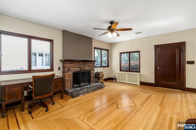 211 Harrison Ave, Hasbrouck Heights, NJ 07604 - living area featuring radiator, ceiling fan, a stone fireplace, and an office area