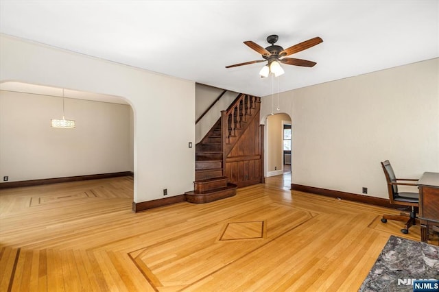 211 Harrison Ave, Hasbrouck Heights, NJ 07604 - unfurnished living room featuring arched walkways, a ceiling fan, and stairs