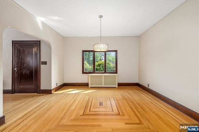 211 Harrison Ave, Hasbrouck Heights, NJ 07604 - spare room featuring radiator heating unit and arched walkways