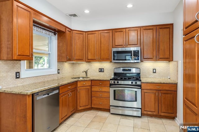 211 Harrison Ave, Hasbrouck Heights, NJ 07604 - kitchen featuring stainless steel appliances, brown cabinetry, light stone countertops, backsplash, and recessed lighting