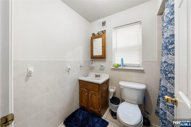 303-305 Runyon St, Newark, NJ 07108 - bathroom with toilet, vanity, tile walls, wainscoting, and tile patterned floors