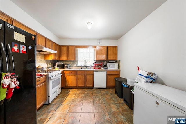 303-305 Runyon St, Newark, NJ 07108 - kitchen with white appliances, under cabinet range hood, brown cabinets, a sink, and light countertops