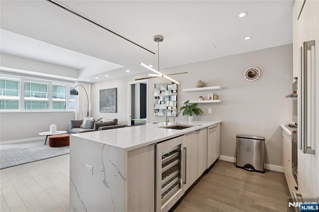 800 Ave At Port Imperial Blvd Unit 517, Weehawken, NJ 07086 - kitchen with wine cooler, a sink, a peninsula, open shelves, and baseboards