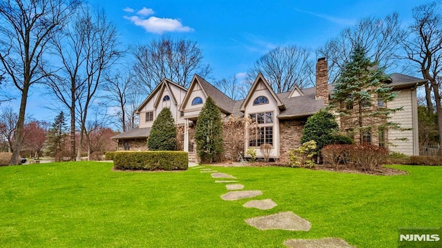 717 Ashmont Rd, Franklin Lakes, NJ 07417 - tudor home with a front yard, a chimney, and stone siding