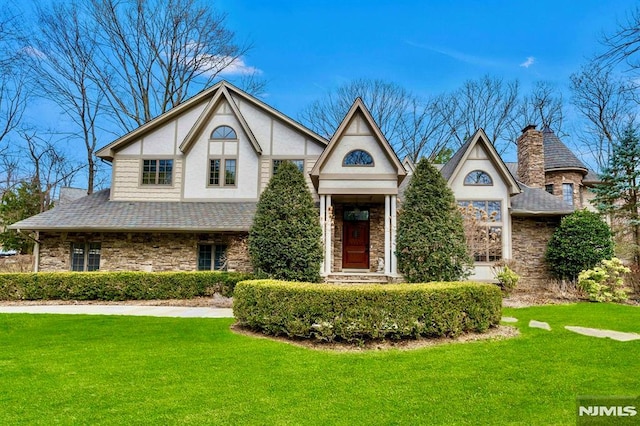 717 Ashmont Rd, Franklin Lakes, NJ 07417 - english style home with stone siding, a front lawn, a shingled roof, a chimney, and stucco siding