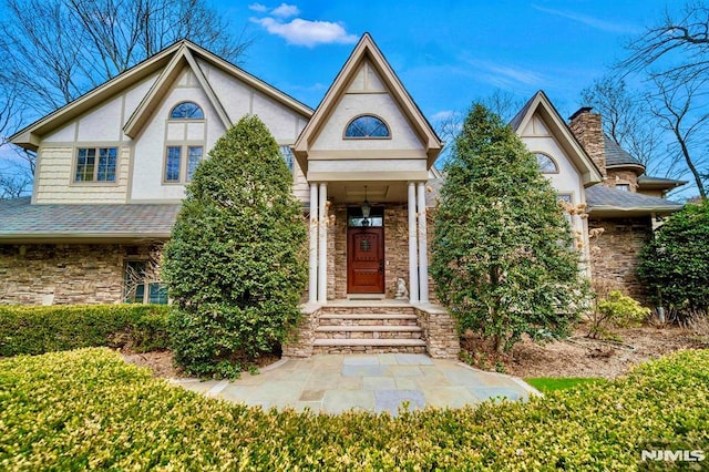 717 Ashmont Rd, Franklin Lakes, NJ 07417 - tudor house featuring stone siding, stucco siding, a shingled roof, and a chimney
