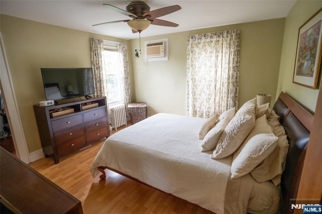 87 Pilch St, Bloomfield, NJ 07003 - bedroom with radiator heating unit, a wall mounted AC, light wood finished floors, and ceiling fan