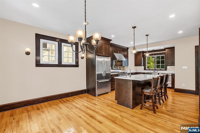 67 Woodland Rd, Bloomfield, NJ 07003 - kitchen featuring stainless steel refrigerator, under cabinet range hood, baseboards, light countertops, and light wood-type flooring
