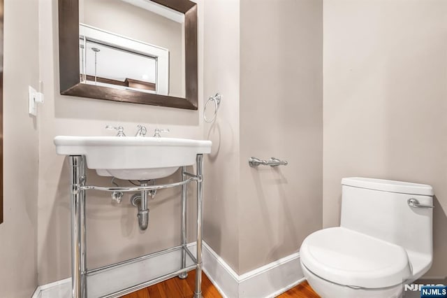 67 Woodland Rd, Bloomfield, NJ 07003 - half bathroom with toilet, wood finished floors, and a sink