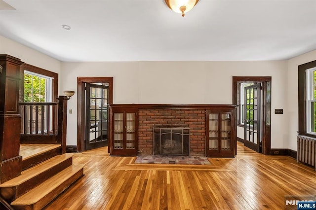 67 Woodland Rd, Bloomfield, NJ 07003 - unfurnished living room featuring radiator heating unit, light wood finished floors, baseboards, and a fireplace