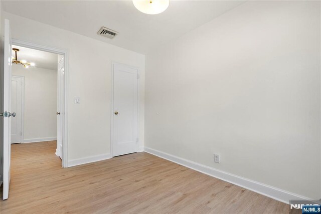 530 Broad Ave Unit 2, Englewood, NJ 07631 - unfurnished bedroom with light wood-style floors, baseboards, and a chandelier