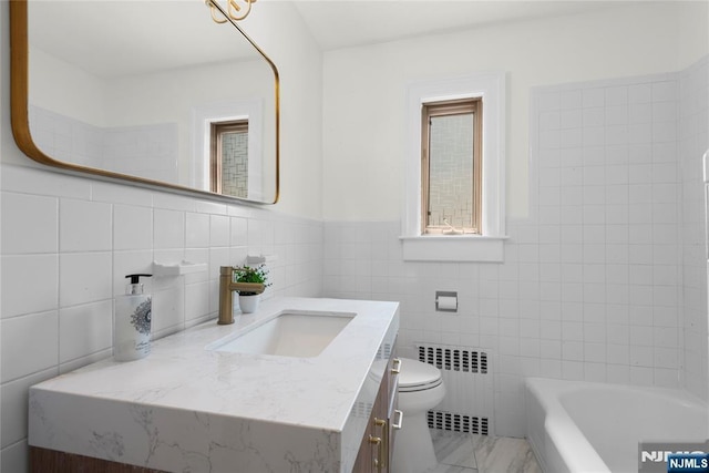 530 Broad Ave Unit 2, Englewood, NJ 07631 - full bath with radiator, vanity, tile walls, a bath, and toilet