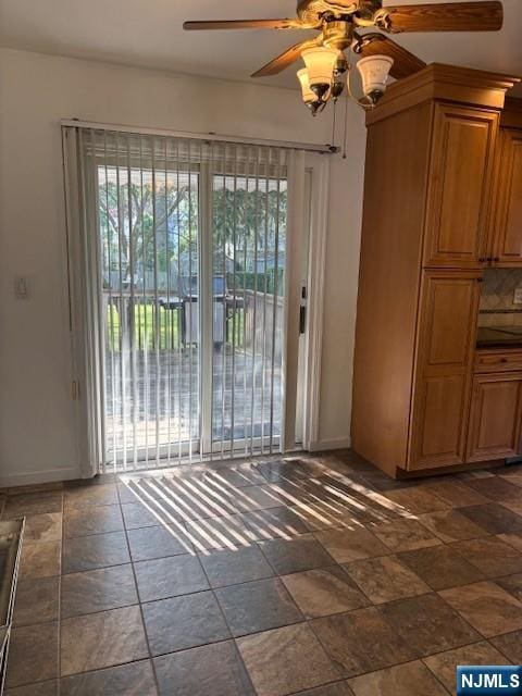 408 Terhune Ave, Paramus, NJ 07652 - unfurnished dining area with a ceiling fan, stone tile floors, and baseboards