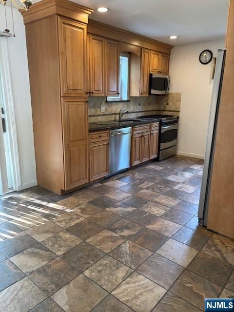 408 Terhune Ave, Paramus, NJ 07652 - kitchen with appliances with stainless steel finishes, dark countertops, baseboards, tasteful backsplash, and brown cabinets