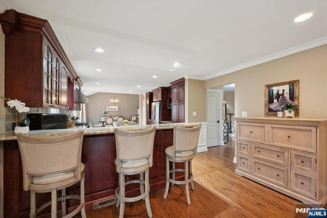 14 Old Chimney Rd, Randolph Township, NJ 07869 - kitchen featuring freestanding refrigerator, glass insert cabinets, a peninsula, light wood-type flooring, and a breakfast bar