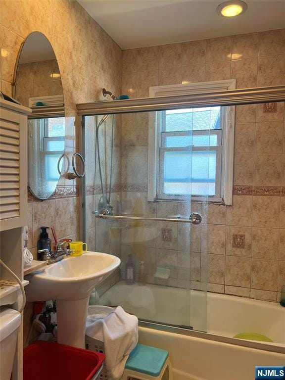 715 Broad Ave Unit 5A, Ridgefield, NJ 07657 - bathroom featuring bath / shower combo with glass door, plenty of natural light, and tile walls