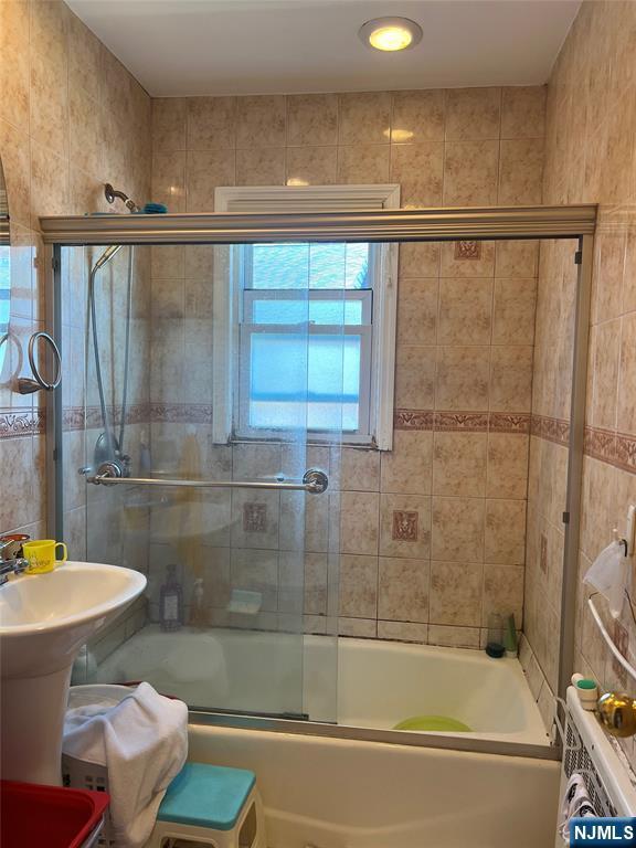 715 Broad Ave Unit 5A, Ridgefield, NJ 07657 - full bathroom with combined bath / shower with glass door and tile walls