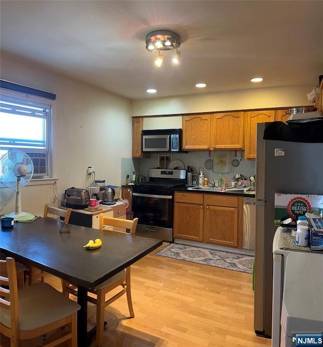 715 Broad Ave Unit 5A, Ridgefield, NJ 07657 - kitchen with stainless steel appliances, brown cabinets, light wood-style floors, dark countertops, and recessed lighting