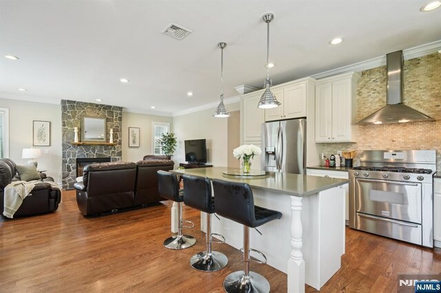 19 Grandview Ave, Glen Rock, NJ 07452 - kitchen with appliances with stainless steel finishes, wall chimney exhaust hood, dark wood finished floors, a kitchen island, and decorative backsplash