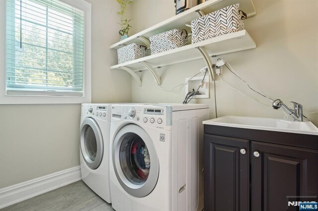 19 Grandview Ave, Glen Rock, NJ 07452 - laundry room with separate washer and dryer, baseboards, light wood-style floors, and cabinet space