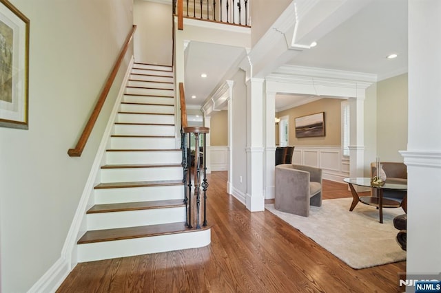 19 Grandview Ave, Glen Rock, NJ 07452 - staircase featuring decorative columns, wood finished floors, a wainscoted wall, crown molding, and a decorative wall