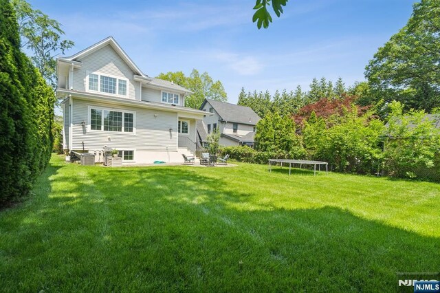 19 Grandview Ave, Glen Rock, NJ 07452 - rear view of property with a trampoline, central AC, a patio, and a lawn
