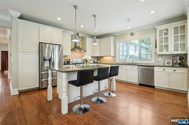 19 Grandview Ave, Glen Rock, NJ 07452 - kitchen with stainless steel appliances, dark countertops, wall chimney exhaust hood, dark wood-style flooring, and ornamental molding
