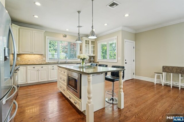 19 Grandview Ave, Glen Rock, NJ 07452 - kitchen with appliances with stainless steel finishes, a kitchen bar, ornamental molding, a sink, and tasteful backsplash