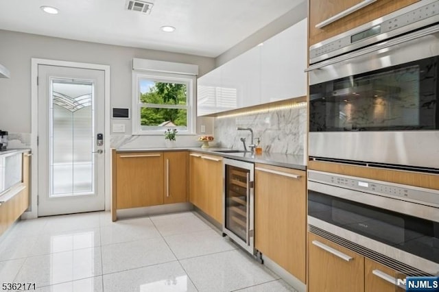3-11 Lyncrest Ave, Fair Lawn, NJ 07410 - kitchen featuring wine cooler, stainless steel oven, light countertops, decorative backsplash, and a sink