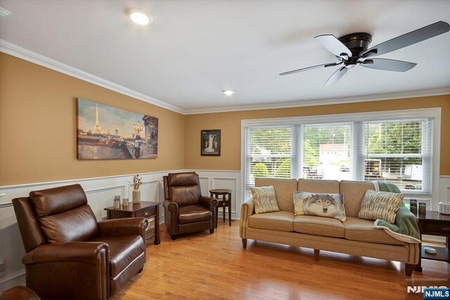 5 Edgewood Ct, Ringwood, NJ 07456 - living area with ornamental molding, healthy amount of natural light, ceiling fan, light wood-style floors, and a wainscoted wall