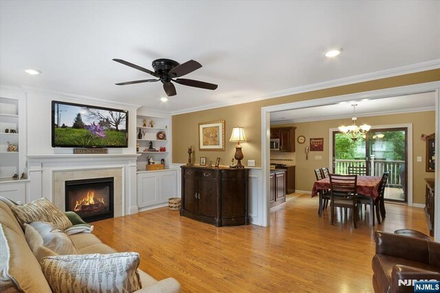 5 Edgewood Ct, Ringwood, NJ 07456 - living area with a ceiling fan, light wood-style flooring, a fireplace, a chandelier, and crown molding