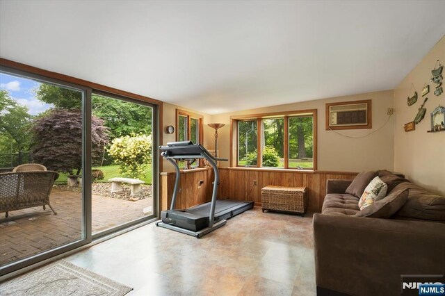 5 Edgewood Ct, Ringwood, NJ 07456 - exercise area featuring healthy amount of natural light, a wall mounted AC, wood walls, a wainscoted wall, and lofted ceiling