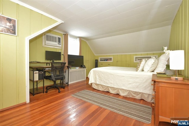408 Eton Ct, Ridgewood, NJ 07450 - bedroom featuring wood finished floors, a wall mounted AC, an office area, a decorative wall, and vaulted ceiling